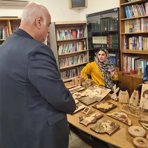 غرفه فروش صنایع دستی چوبی در بازارچه خیریه، شامل جعبه‌های منبت‌کاری شده و ظروف چوبی